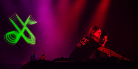 Deux personnes DJ mixant sur scène.