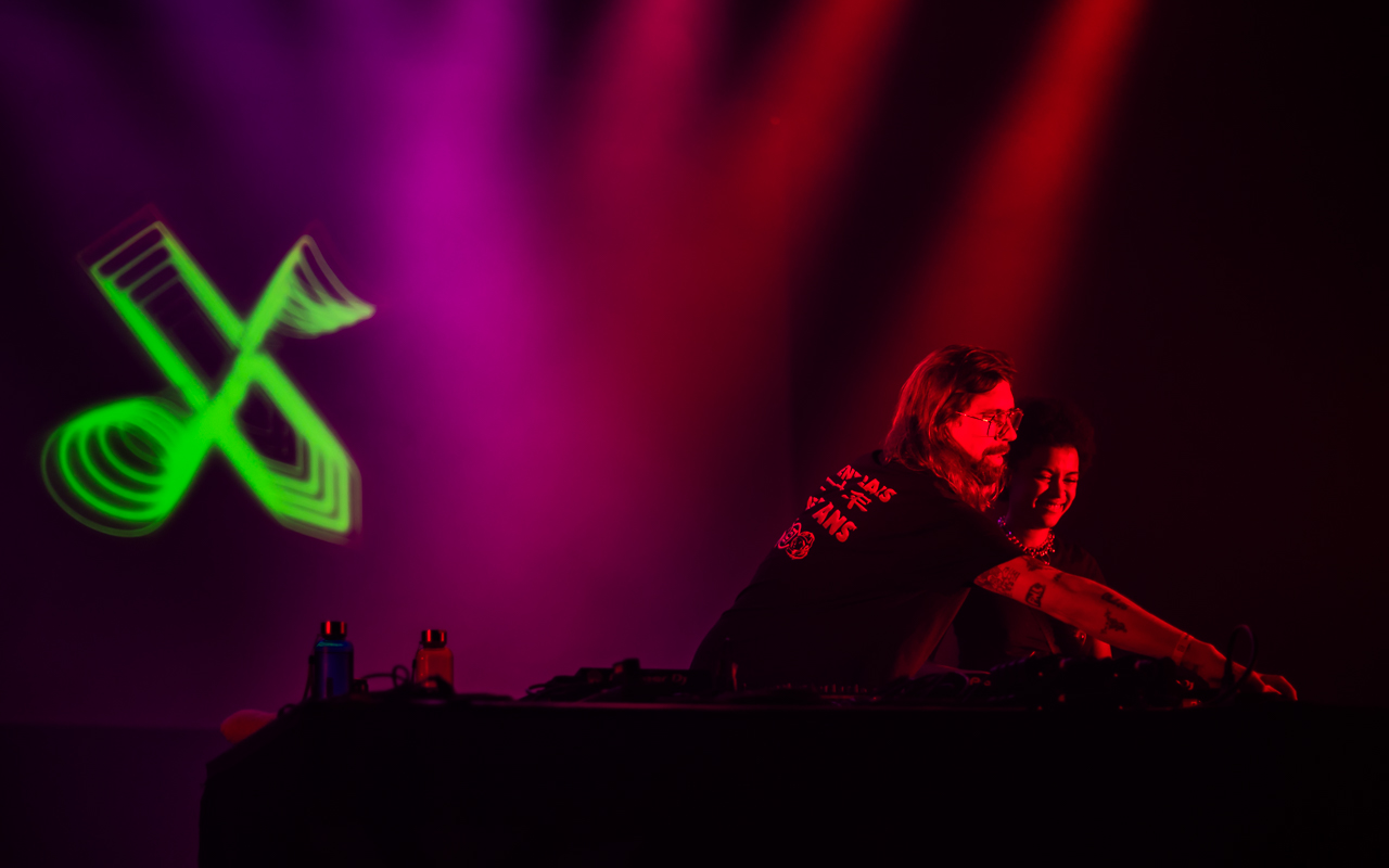 Deux personnes DJ mixant sur scène.