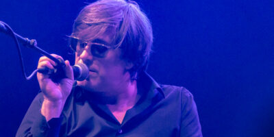 Chanteur sur scène avec lunettes de soleil.