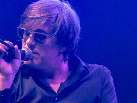 Chanteur sur scène avec lunettes de soleil.