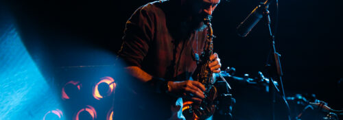Musicien jouant du saxophone sur scène.
