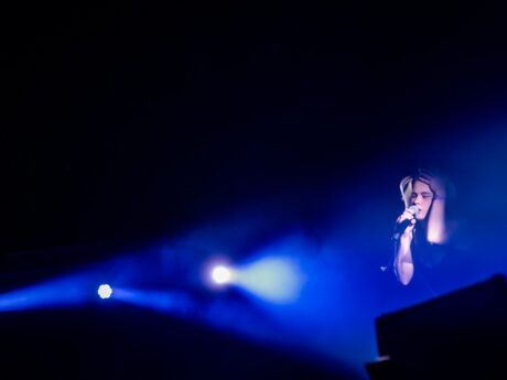 Chanteur sur scène avec lumière bleue intense.