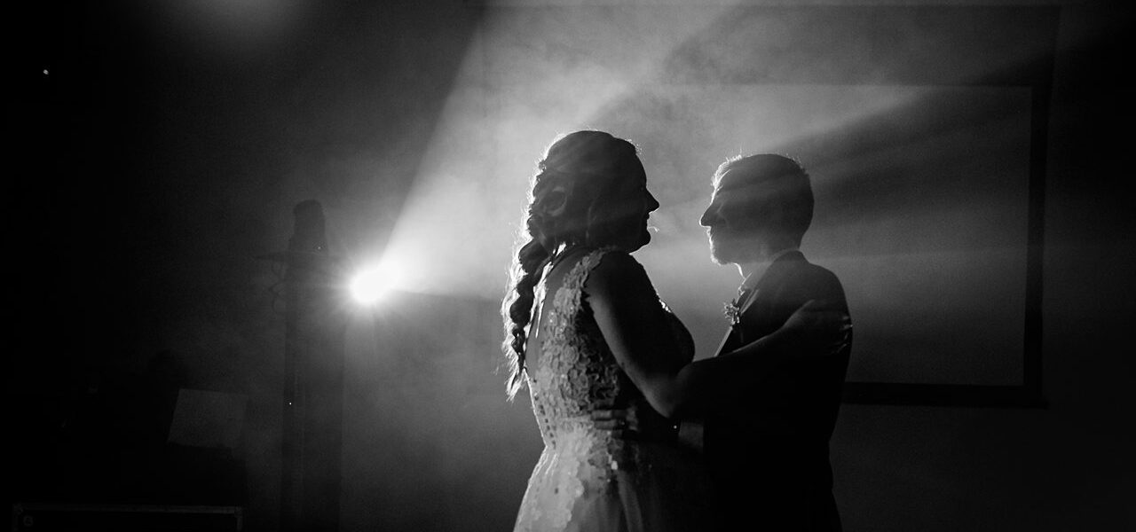 Couple dansant dans la lumière, ambiance romantique.