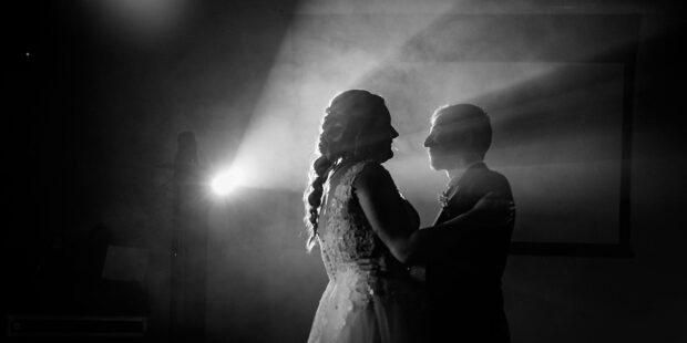 Couple dansant dans la lumière, ambiance romantique.