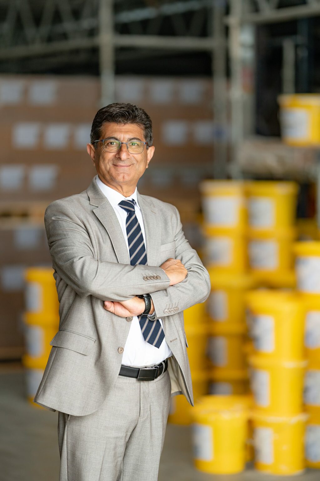 Homme souriant en costume dans un entrepôt