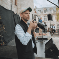 Photographe tenant un appareil photo lors d'un événement.