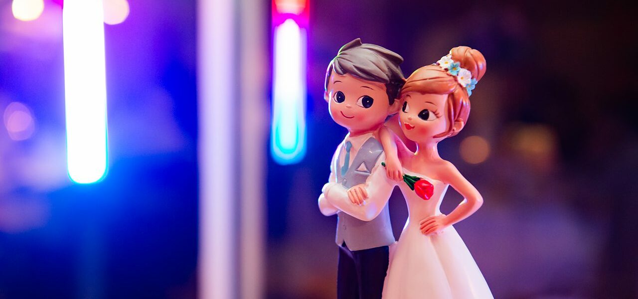Figurines de mariage sur fond coloré.