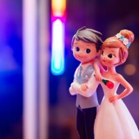 Figurines de mariage sur fond coloré.