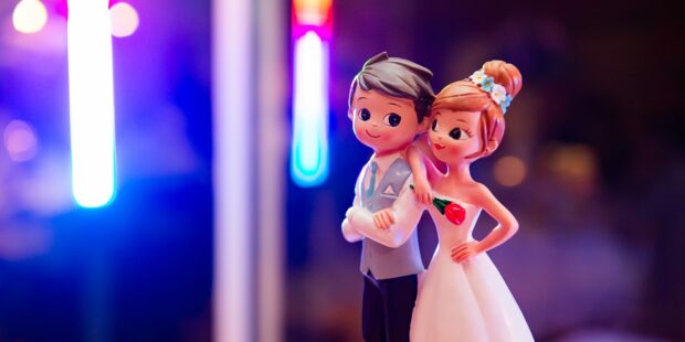 Figurines de mariage sur fond coloré.