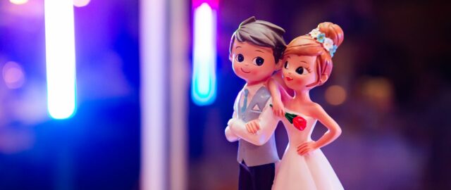 Figurines de mariage sur fond coloré.