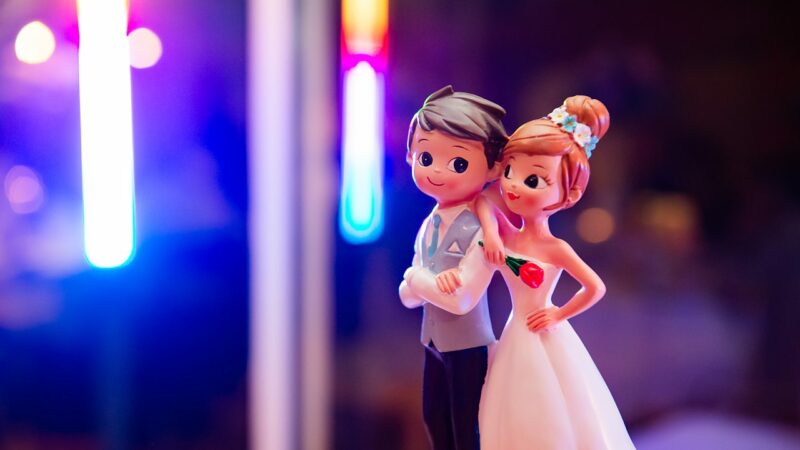 Figurines de mariage sur fond coloré.