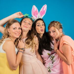 Quatre femmes souriantes avec oreilles de lapin roses.