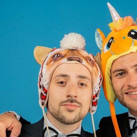 Deux hommes avec chapeaux d'animaux rigolos.