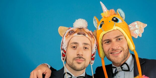 Deux hommes avec chapeaux d'animaux rigolos.