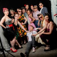 Groupe de femmes et homme posant dans un studio.