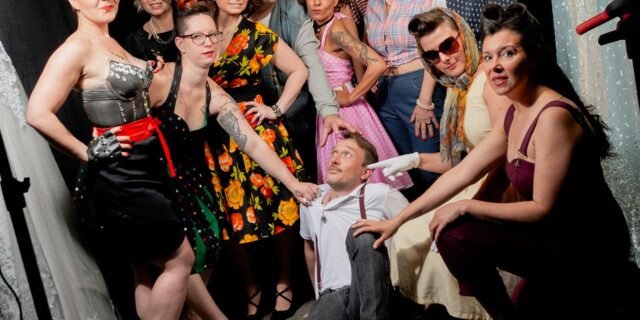 Groupe de femmes et homme posant dans un studio.