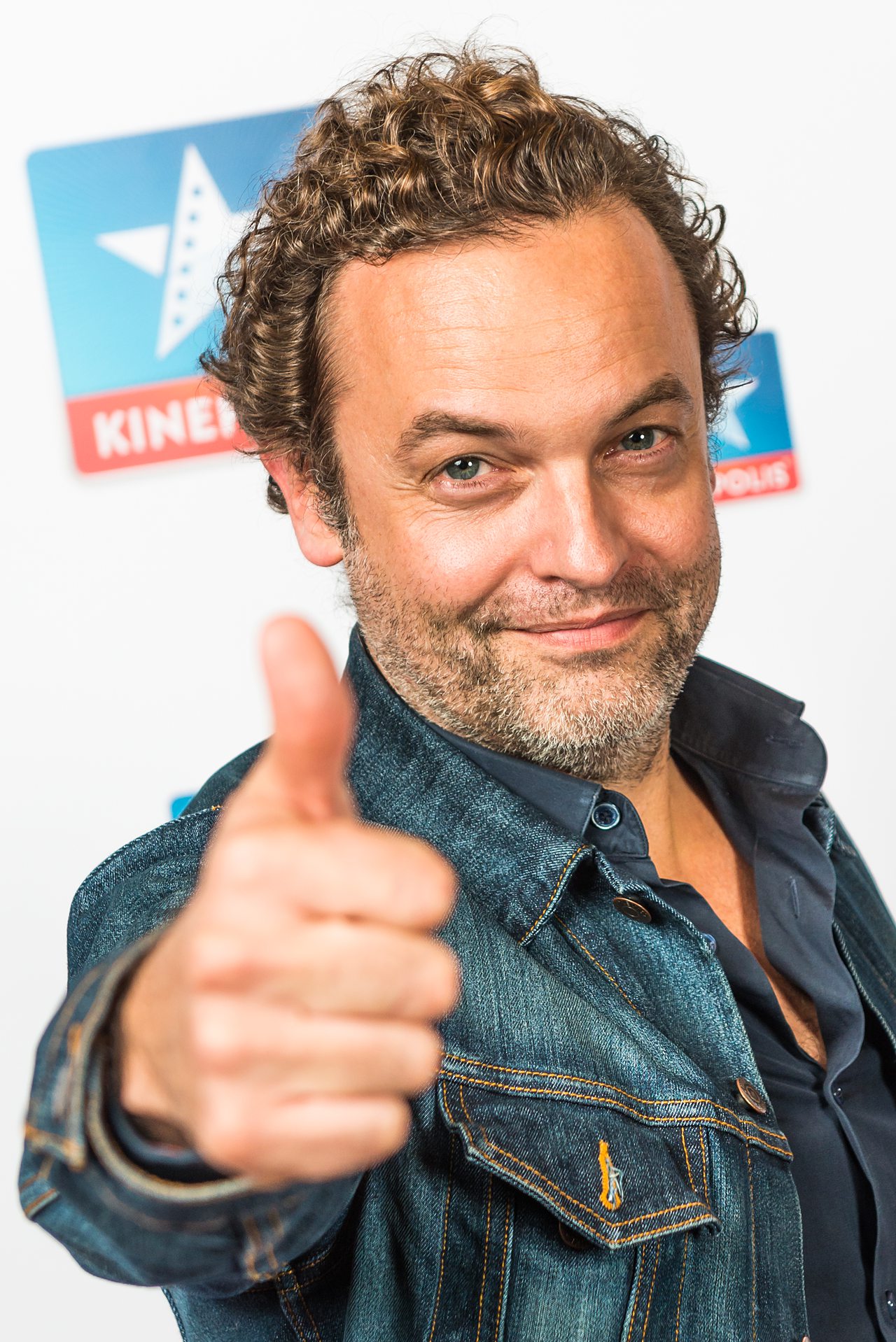Homme souriant avec un pouce levé.