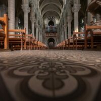 Intérieur d'église avec bancs et vitraux colorés.