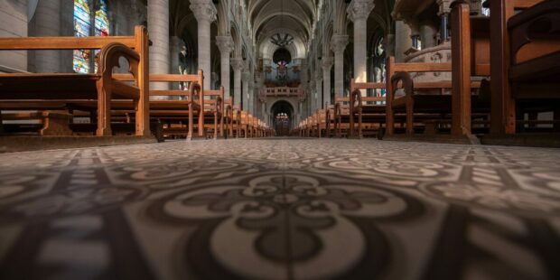 Intérieur d'église avec bancs et vitraux colorés.