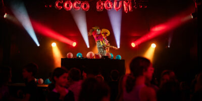 DJ en costume lumineux lors d'une fête colorée.