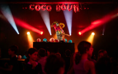 DJ en costume lumineux lors d'une fête colorée.