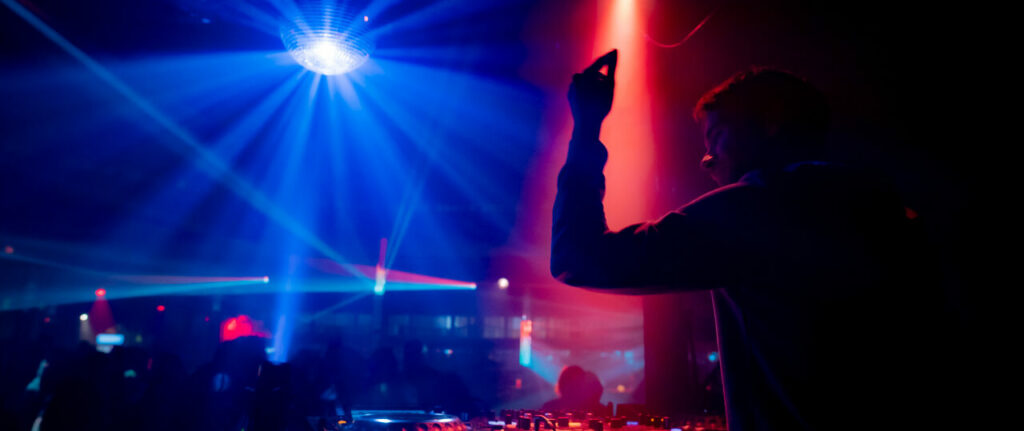 DJ animant une soirée dansante avec jeux de lumière.