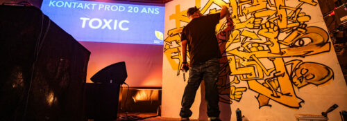 Artiste peignant graffiti lors d'un événement.