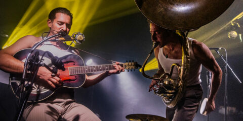 Musiciens jouant sur scène avec guitare et tuba.