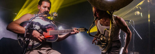 Musiciens jouant sur scène avec guitare et tuba.
