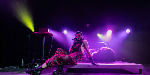 Artiste masqué sur scène, lumière colorée