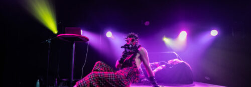 Artiste masqué sur scène, lumière colorée