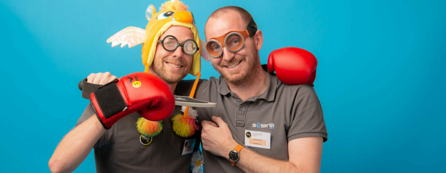 Deux hommes souriant avec déguisements et jouets.