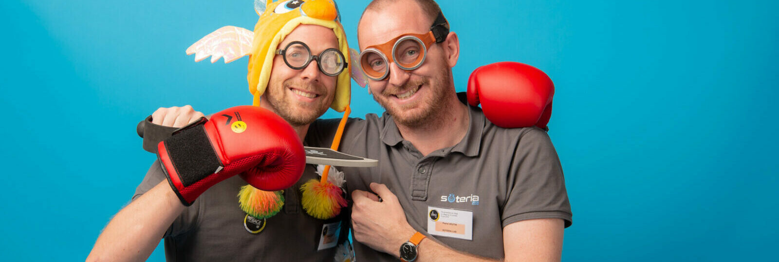 Deux hommes souriant avec déguisements et jouets.