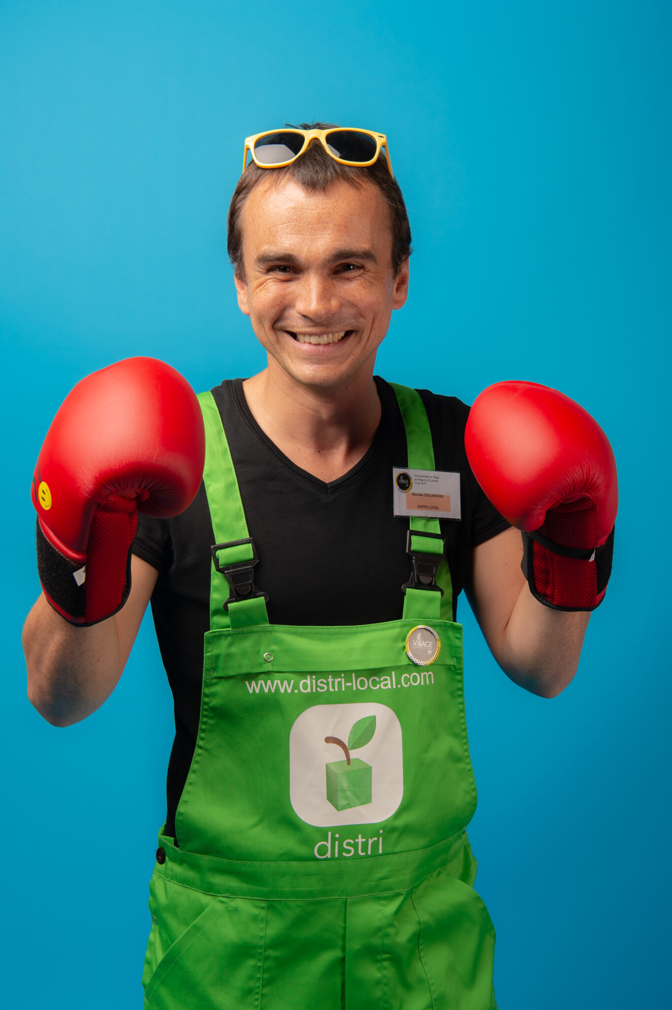 Homme souriant avec des gants de boxe rouges.