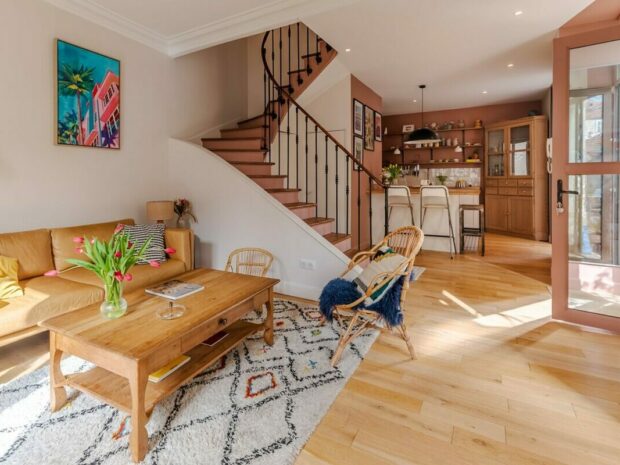 Salon lumineux avec escalier en bois.