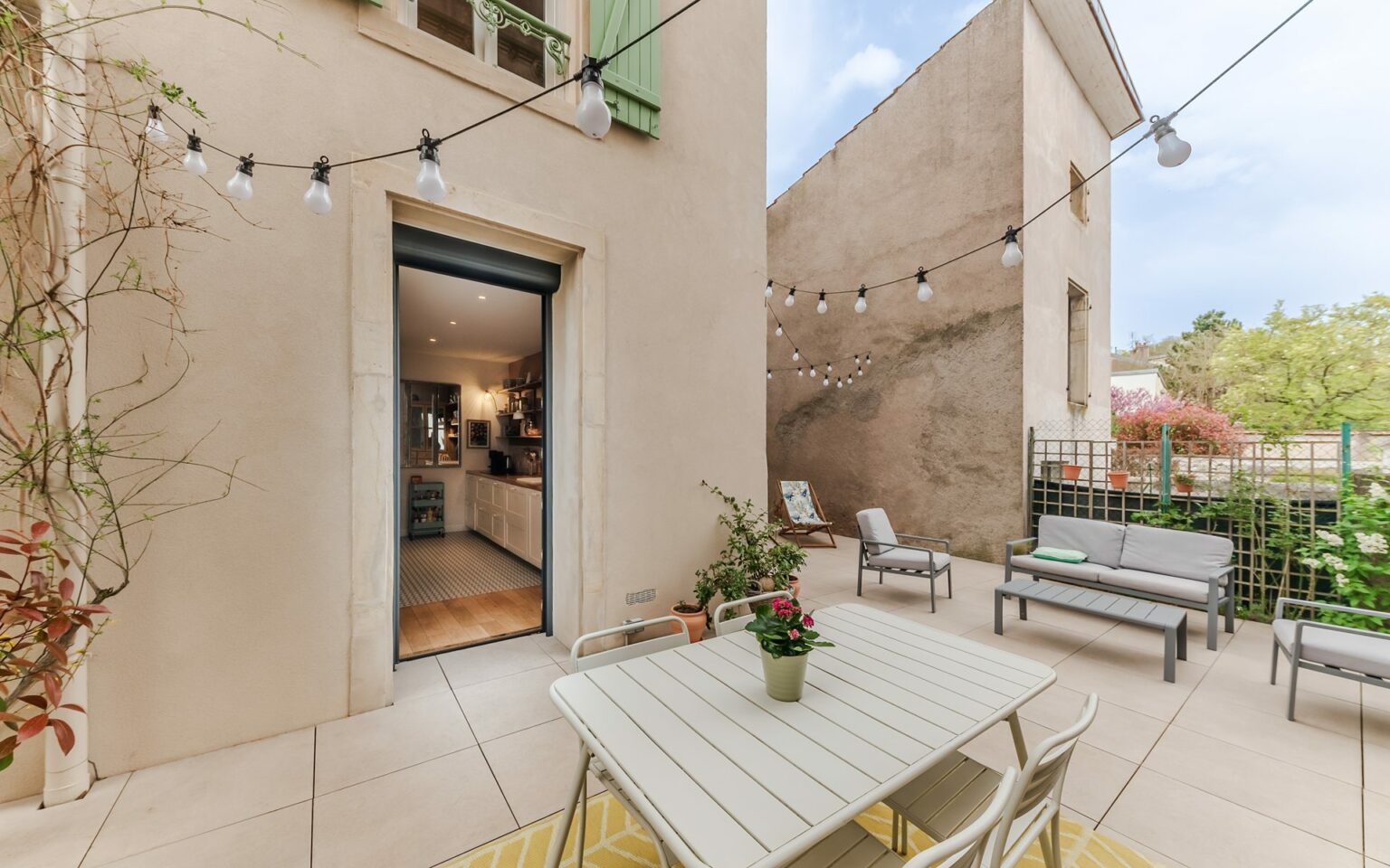 Terrasse avec mobilier et guirlandes lumineuses.