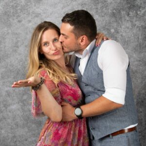 Un homme embrasse une femme, fond gris.