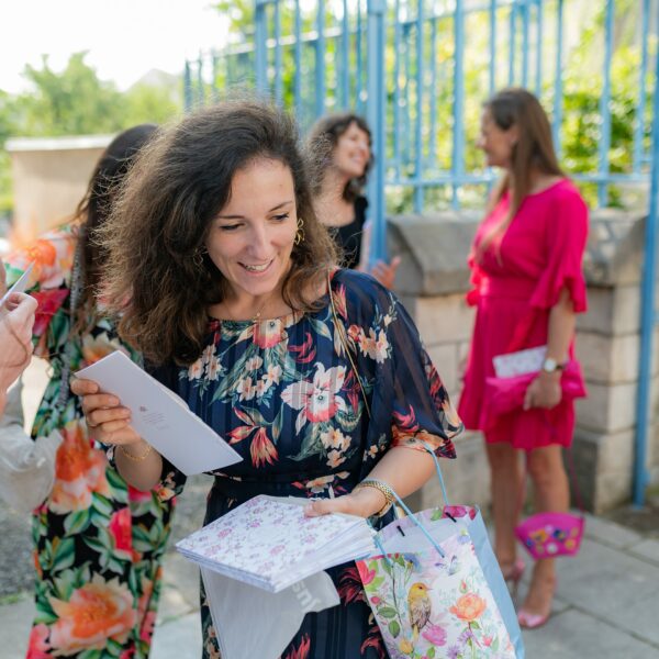 Femme souriante avec cartes et cadeaux colorés.