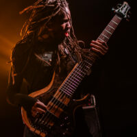 Musicien jouant de la guitare basse sur scène.