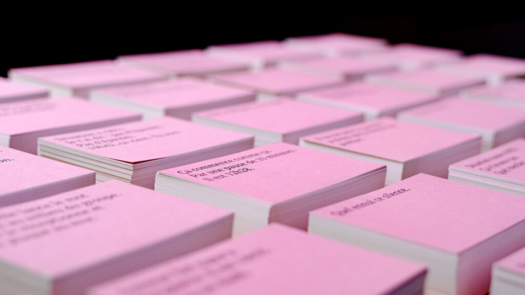 Cartes roses empilées avec texte visible.
