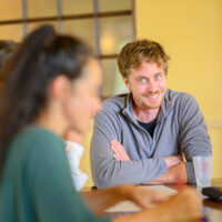 Groupe de personnes discutant autour d'une table.