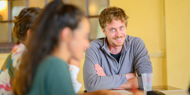 Groupe de personnes discutant autour d'une table.