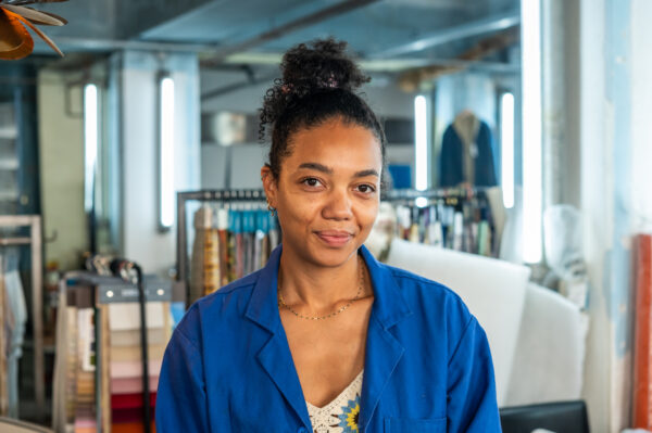 Femme souriante en blouse bleue dans un atelier