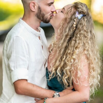 Couple s'embrassant tendrement dans un parc verdoyant.