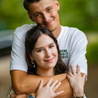 Couple s'enlaçant dans un parc verdoyant.