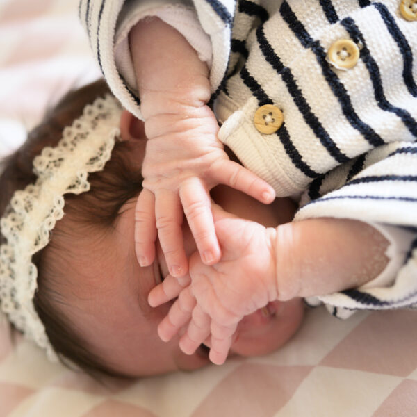 Bébé endormi avec bandeau et pyjama rayé.