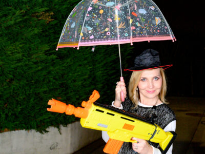 Femme avec parapluie transparent et jouet coloré.