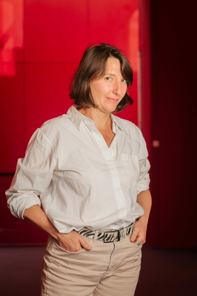 Personne en chemise blanche sur fond rouge.