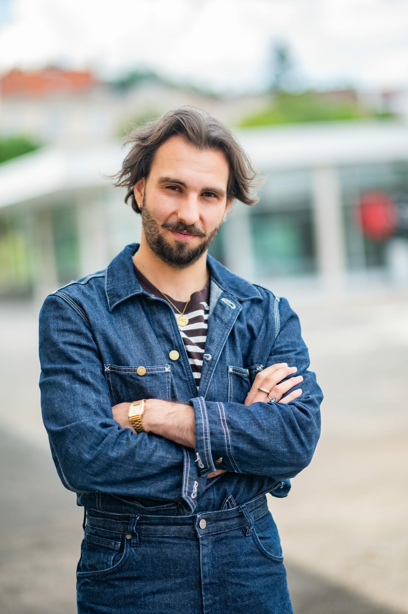 Homme en veste en jean croisant les bras.