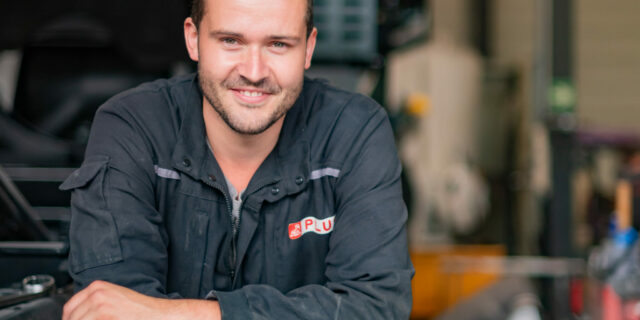 Homme souriant dans un atelier de réparation.